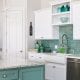 Beautiful, freshly remodeled kitchen with green tile back splash, white cabinets and a granite counter top.